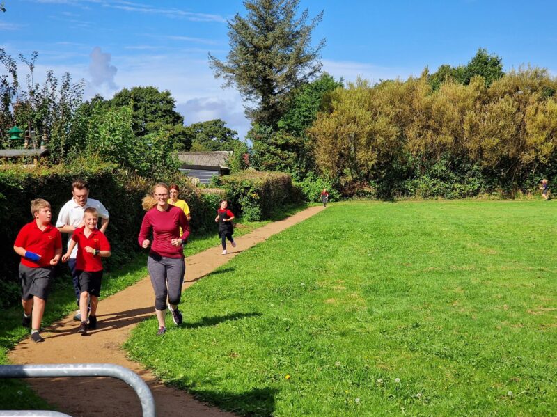 Cat, staff, and pupils running their daily mile!